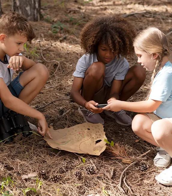 Home 2 QRiosity Kids looking at a map in the forest